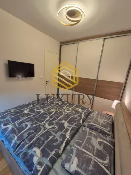 Spavaća soba sa bračnim krevetom, velikim garderoberom i televizorom na zidu. - image 4