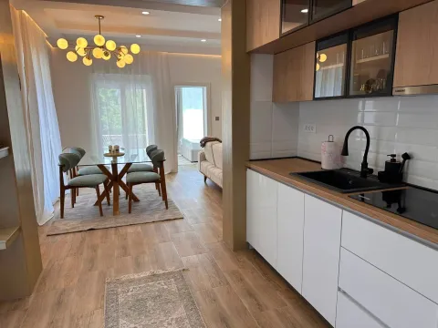 Moderna kuhinja sa bijelim elementima i trpezarija sa staklenim stolom u produžetku. - image 6