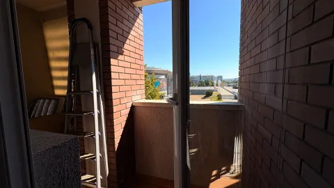 View from the balcony overlooking the city and surrounding buildings. - image 13
