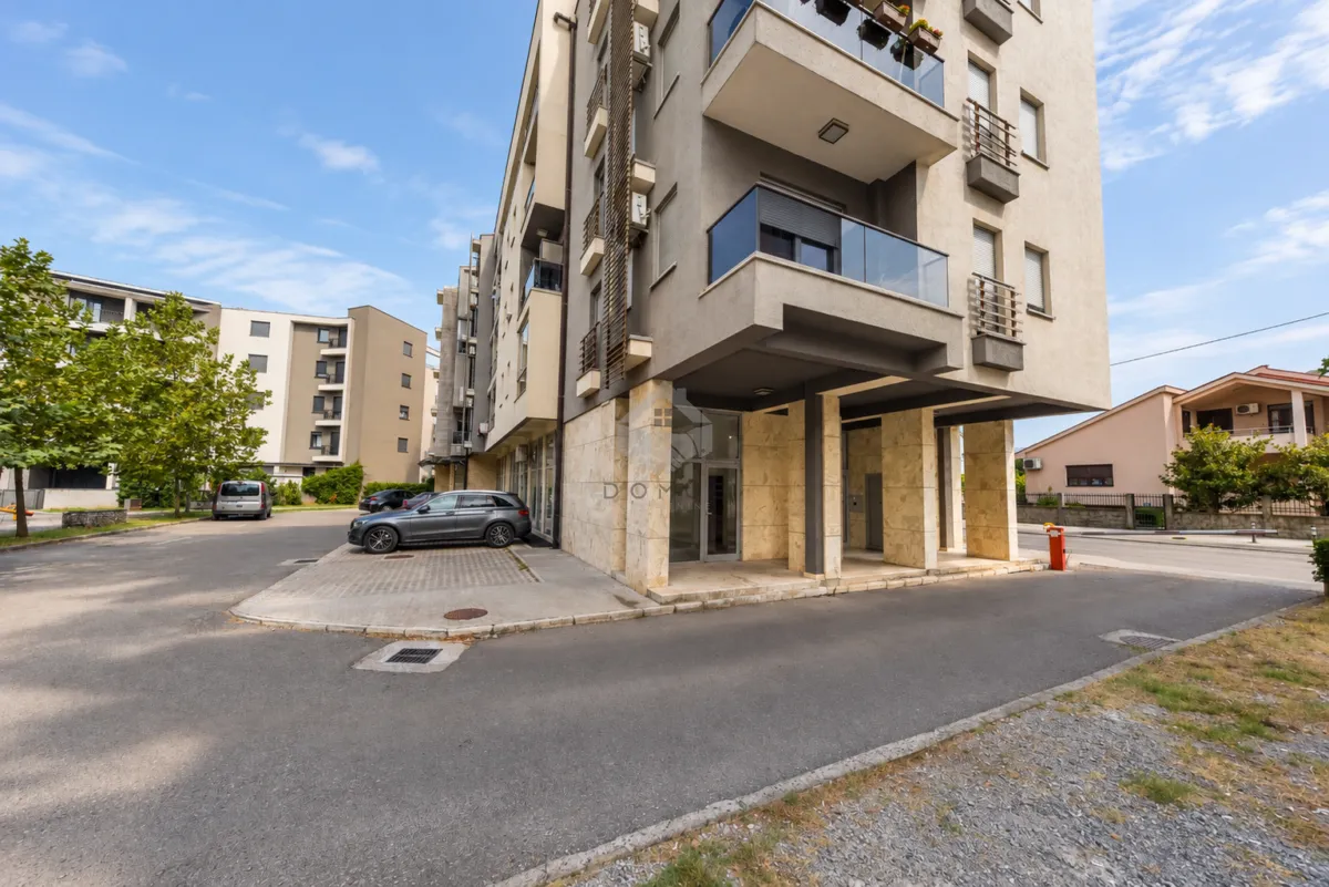 View of the exterior of the residential building and parking in front of the entrance.