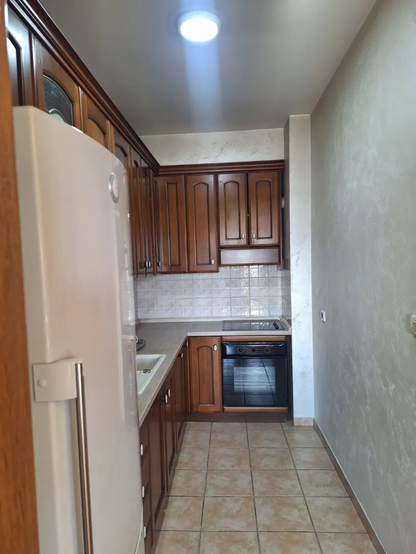 Smaller kitchen with wooden cabinets and built-in oven.