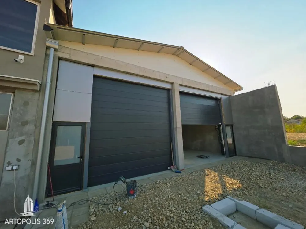 Exterior view of the building with garage doors under construction.