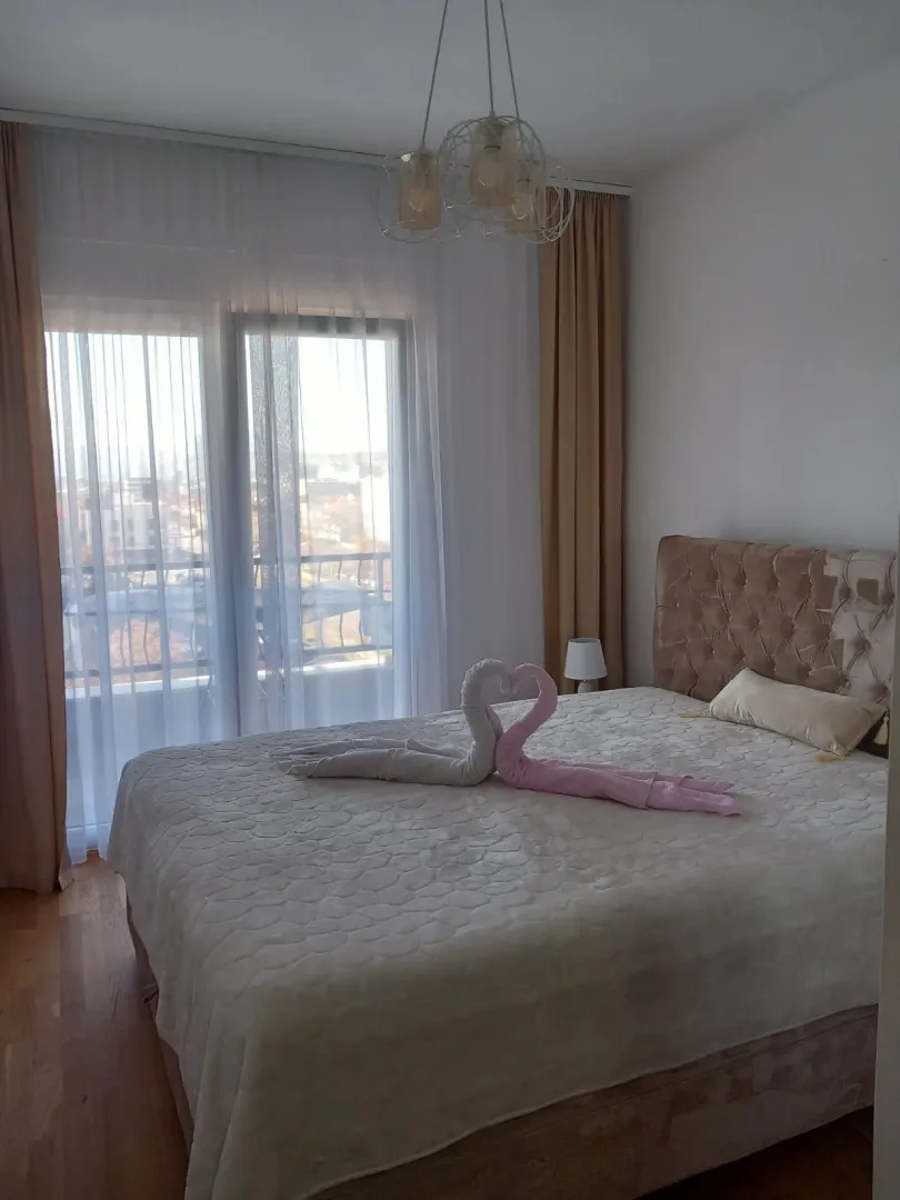 Bright bedroom featuring a double bed decorated with towel swans.