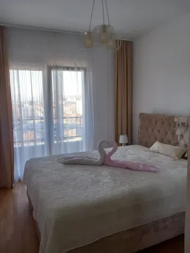 Bright bedroom featuring a double bed decorated with towel swans. - image 3