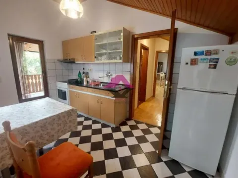 Kuhinja sa drvenim elementima, trpezarijskim stolom i frižiderom. - image 19