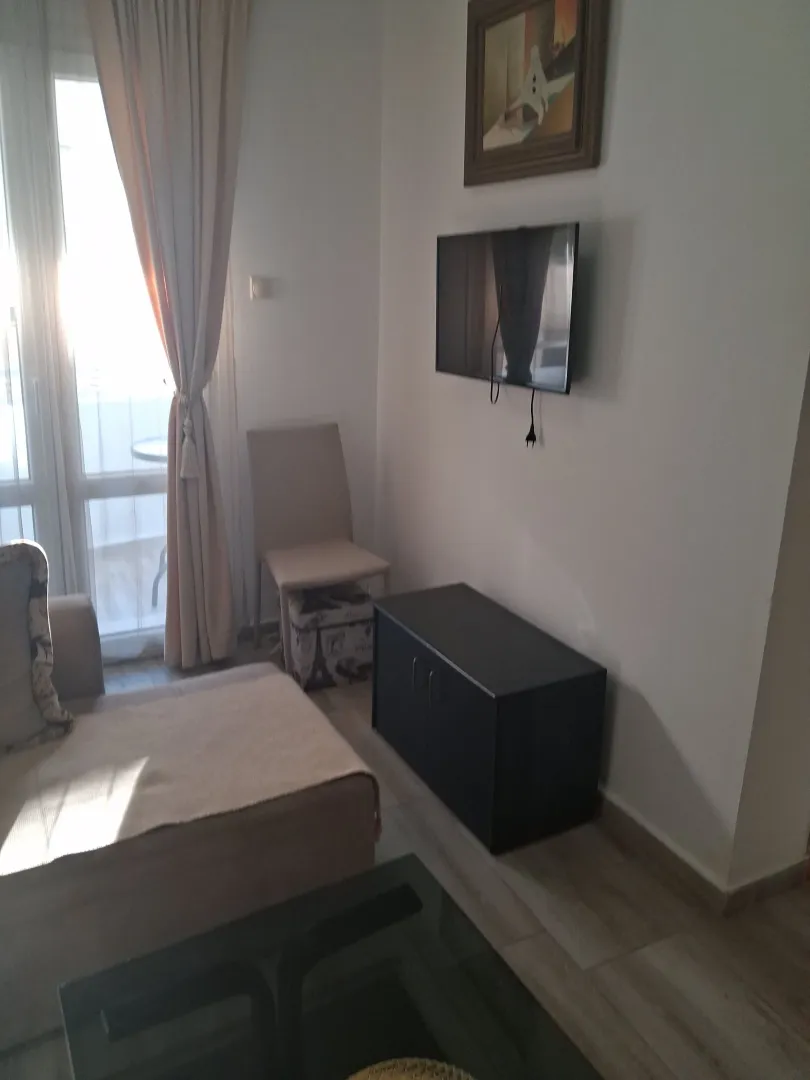 Smaller living room with sofa, TV and access to the terrace.