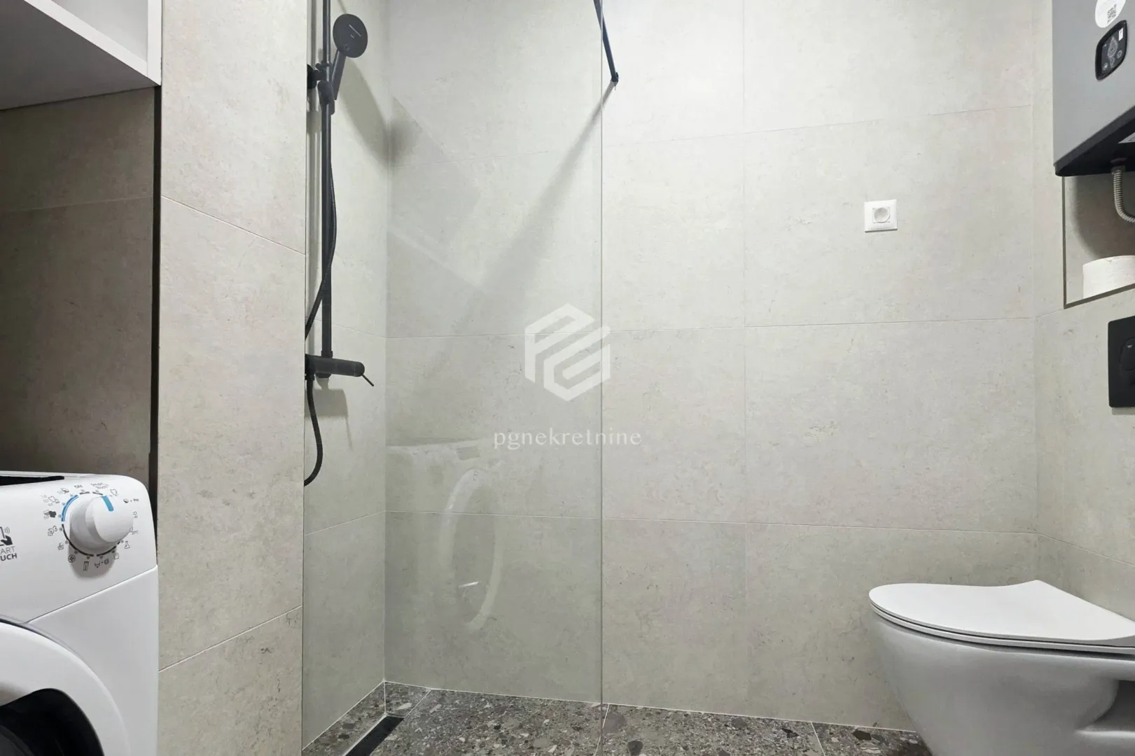 Modern bathroom equipped with a walk-in shower and a washing machine.