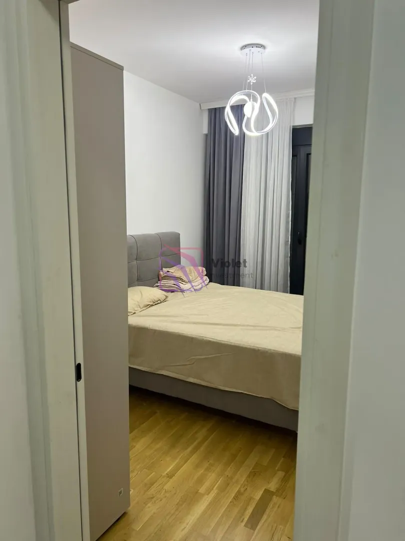 Pogled iz hodnika na namještenu spavaću sobu sa bračnim krevetom.