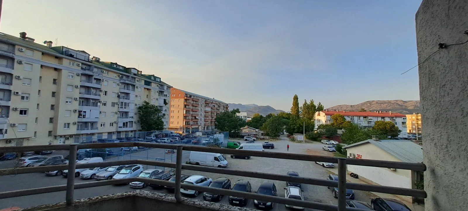 Pogled sa terase na okolne zgrade i parking.