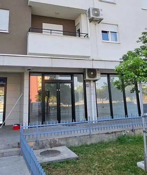 Exterior view of a commercial space on the ground floor of a building with large glass storefront.