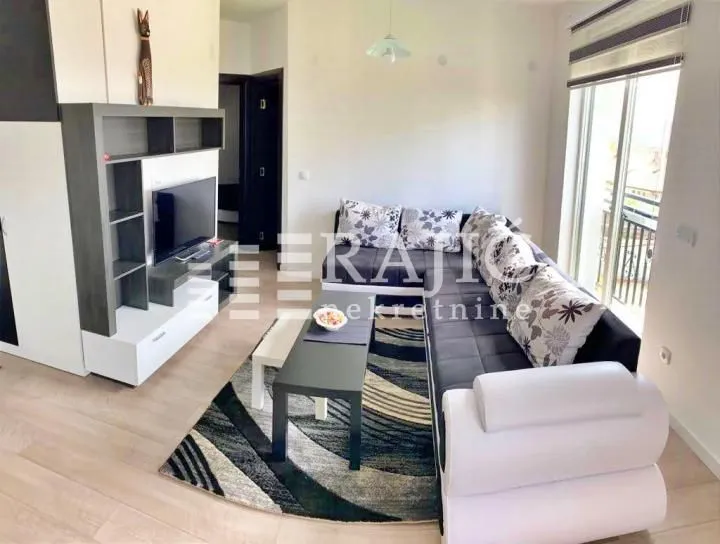 Furnished living room with sofa set and TV.