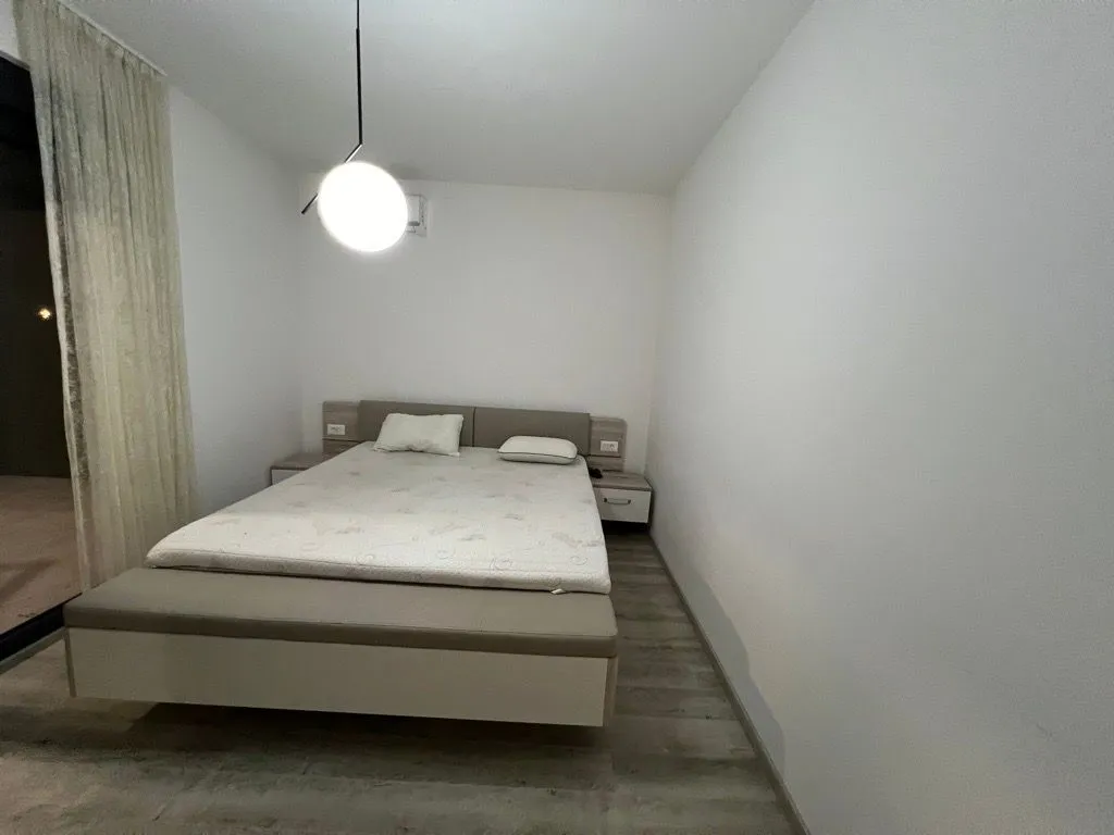 A bedroom with a double bed and modern lighting.