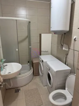 Bathroom equipped with a shower cabin, washbasin, toilet, water heater, and washing machine. - image 7
