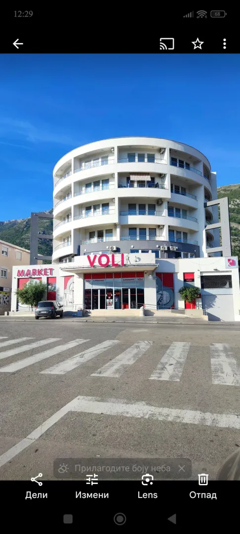 Exterior view of the residential and commercial building with a supermarket on the ground floor.