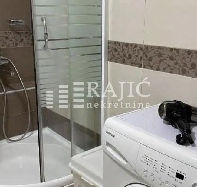 Bathroom with a shower cabin and a washing machine.