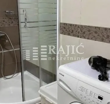 Bathroom with a shower cabin and a washing machine. - image 7