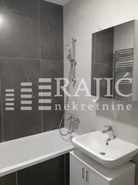 Modernly equipped bathroom with a bathtub, washbasin, and mirror. - image 11