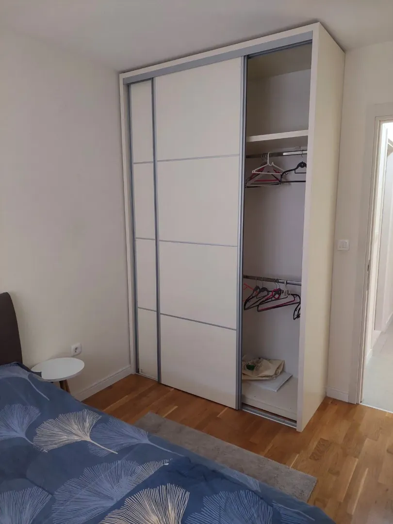 Spavaća soba sa velikim ugradnim garderoberom i krevetom.
