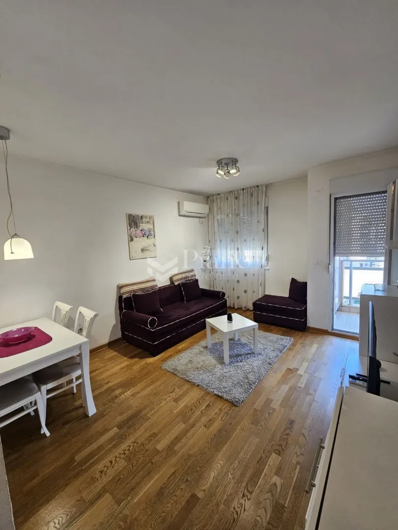 Living room with sofa, dining table and access to the terrace.