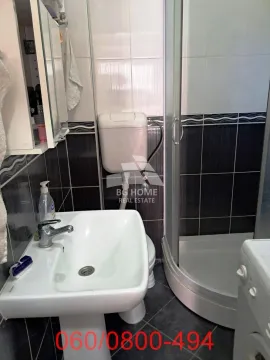 Manje kupatilo sa umivaonikom, tuš kabinom i pločicama u kontrastnim bojama. - image 12
