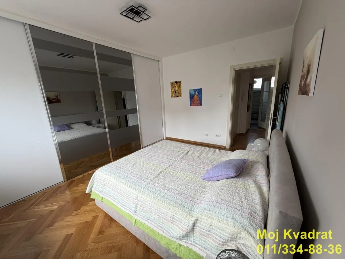 Bedroom with a double bed and a large built-in mirrored wardrobe.