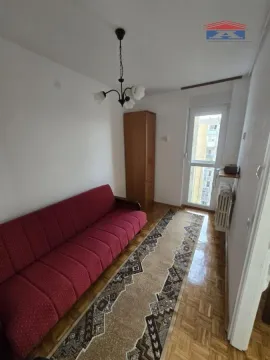 Manja soba sa crvenim kaučem, ormarom i parketom. - image 6