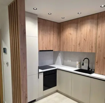 Modern kitchen with wooden cabinetry and built-in appliances. - image 4