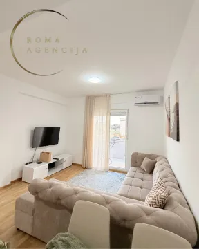 Bright living room with a sectional sofa and TV unit. - image 2