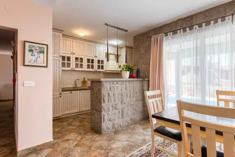Kuhinja sa šankom i trpezarijskim stolom pored prozora. - image 10