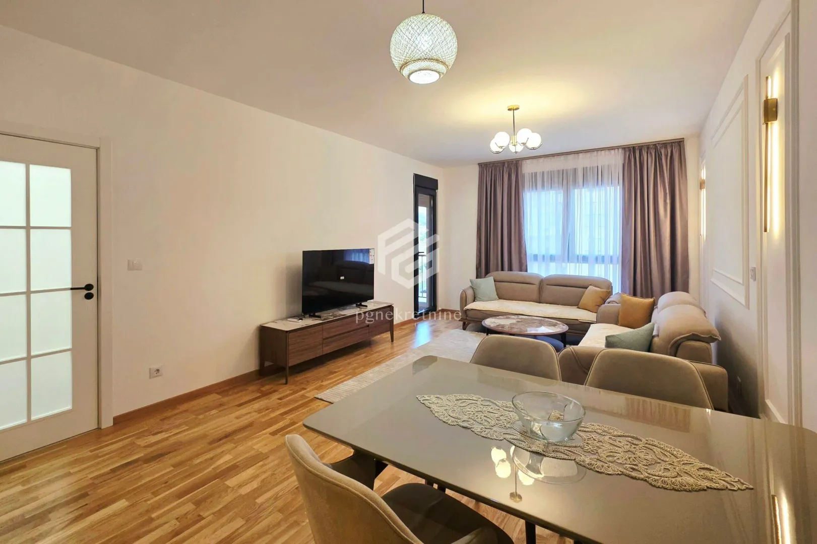 Spacious living room with a sofa set, TV, and dining table.