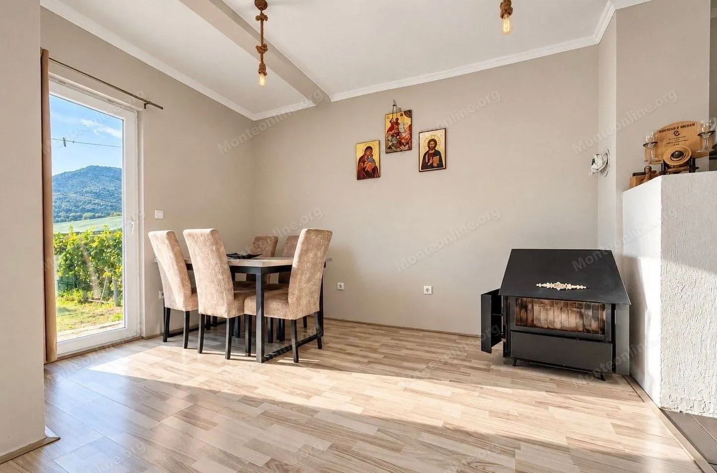 Living room with dining area, wood-burning stove, and access to the terrace.
