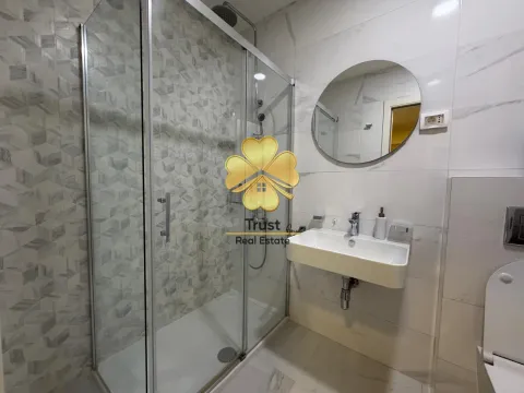 Modern bathroom with a shower cabin, washbasin, and mirror. - image 10