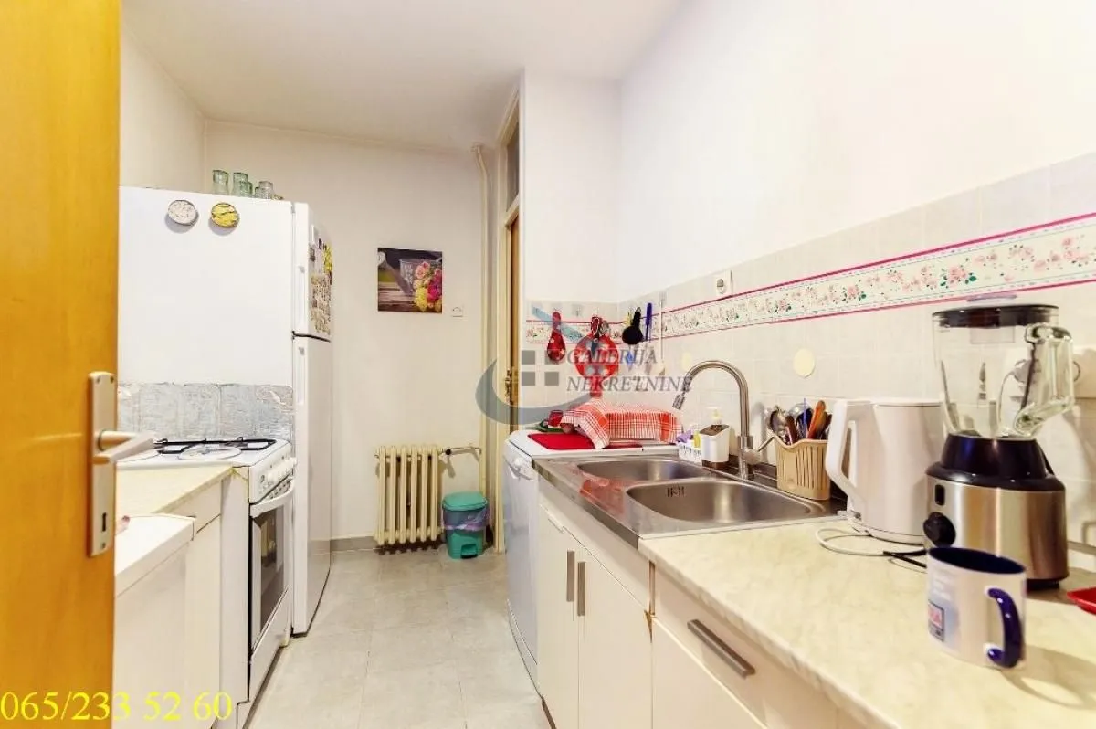 Small kitchen with a sink, countertop, and refrigerator.