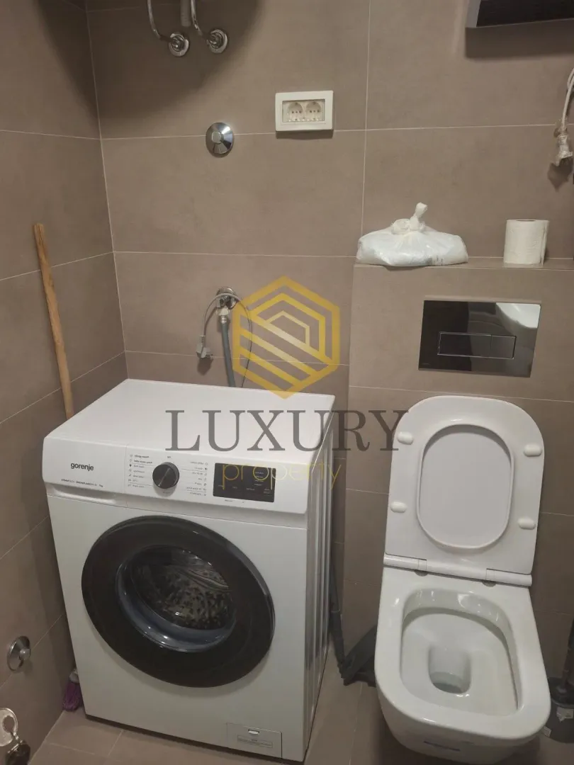 Bathroom with a washing machine and toilet.