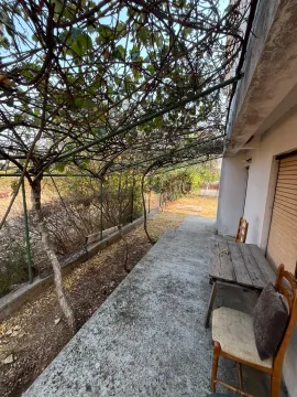 Natkrivena terasa sa stolom i stolicama ispred kuće. - image 7
