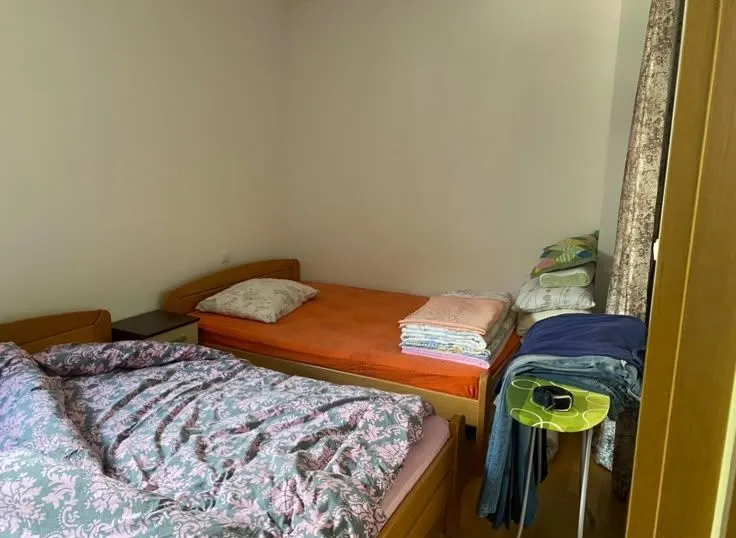Bedroom with two beds and folded bedding.