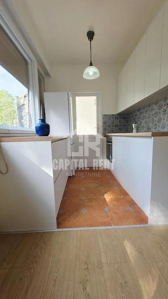 Smaller kitchen with white cabinetry and a window.