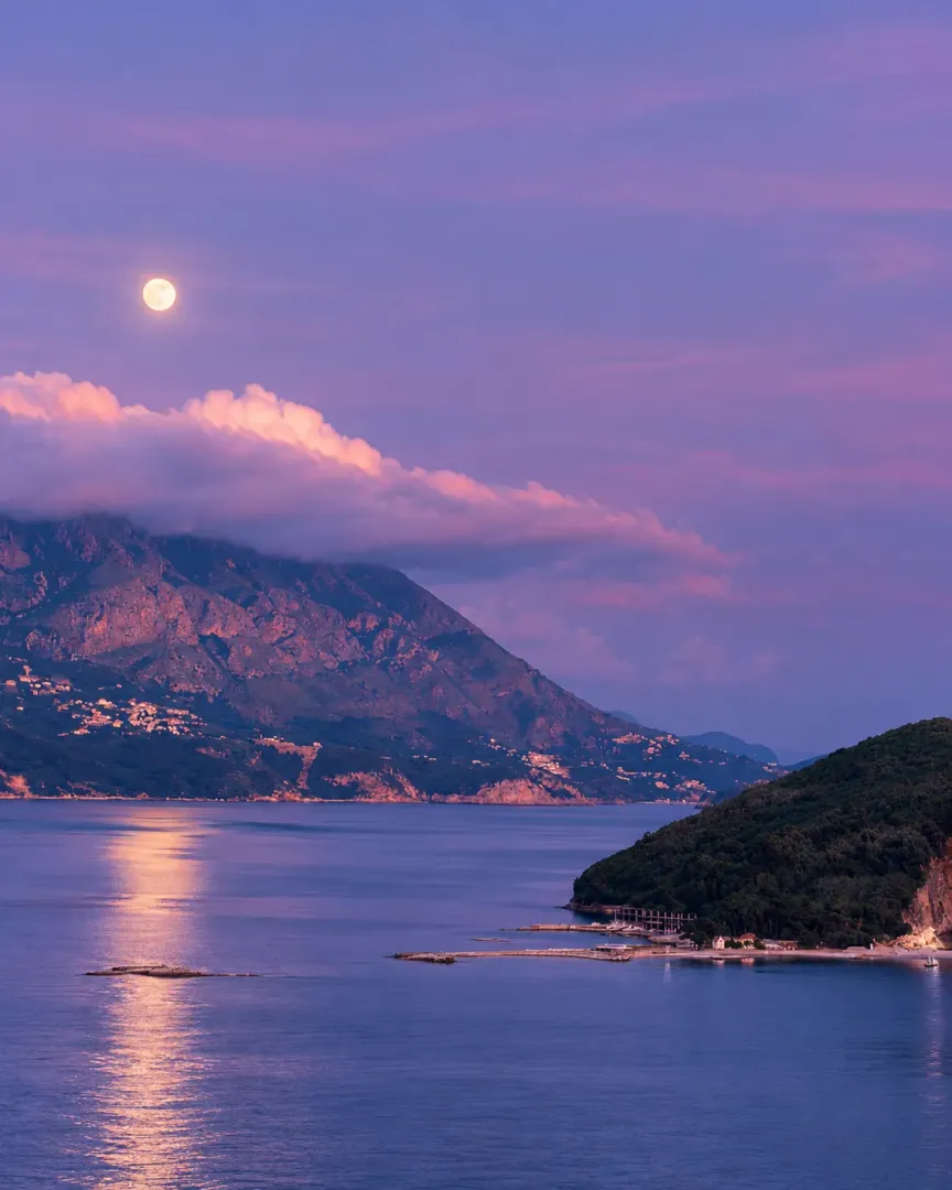 View of the sea and mountains with moonlight at dusk.