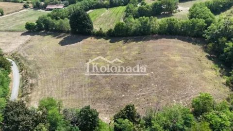 Pogled iz vazduha na prostranu parcelu okruženu zelenilom i prirodom. - image 5