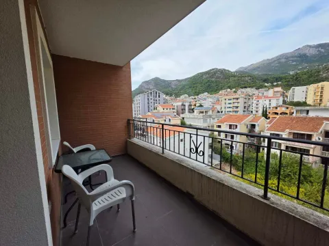 Natkriveni balkon sa garniturom za sjedenje i pogledom na grad i planine. - image 2