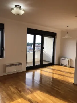 Bright empty room with wooden flooring and access to a balcony. - image 5