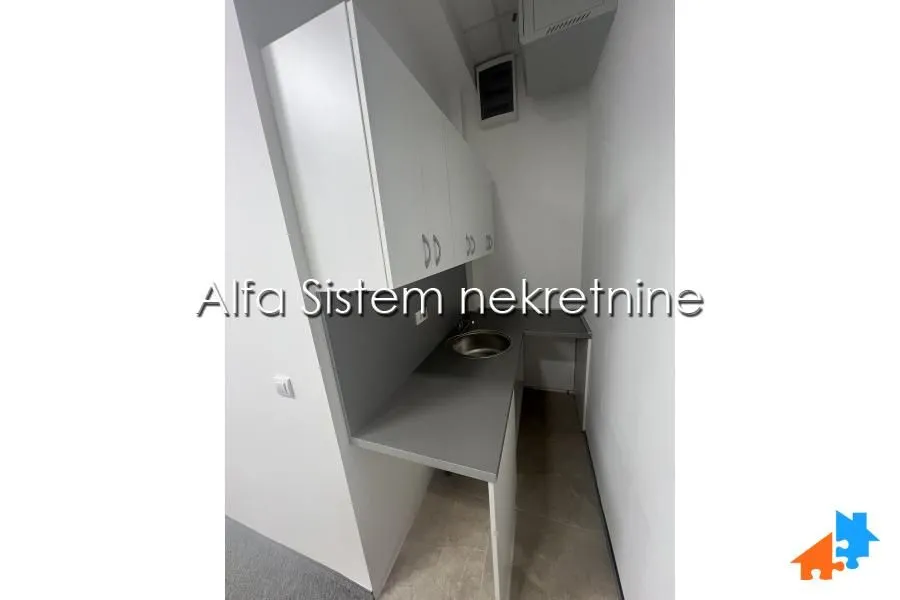 Small white kitchen with a sink and wall cabinets.