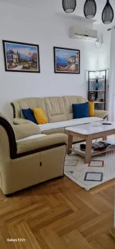Living room with a sofa set, coffee table, and paintings on the wall. - image 10