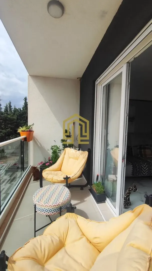 Namještena terasa sa udobnim foteljama i pogledom na zelenilo.