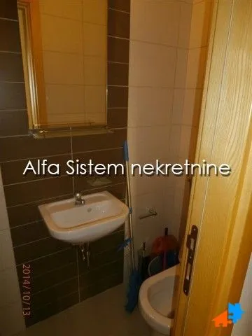 Manje kupatilo sa umivaonikom, ogledalom i toaletom.
