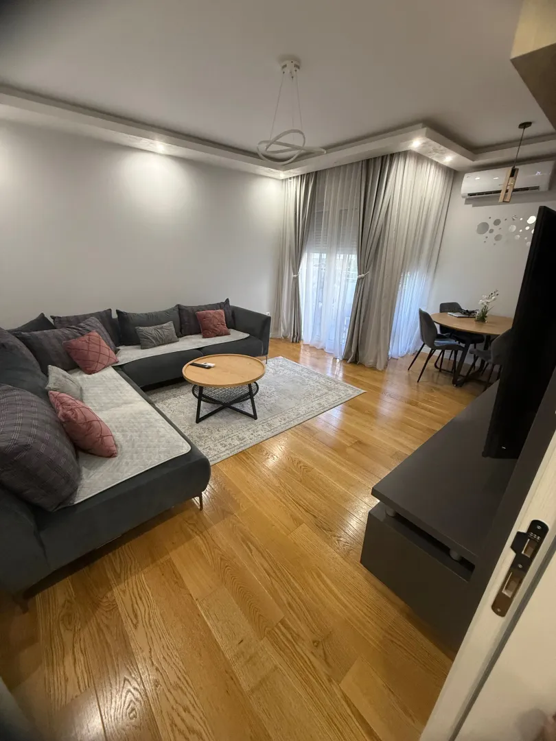Dnevna soba sa garniturom, stočićem i trpezarijskim dijelom u pozadini.