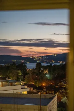 Pogled na more i grad u sumrak sa prozora. - image 11