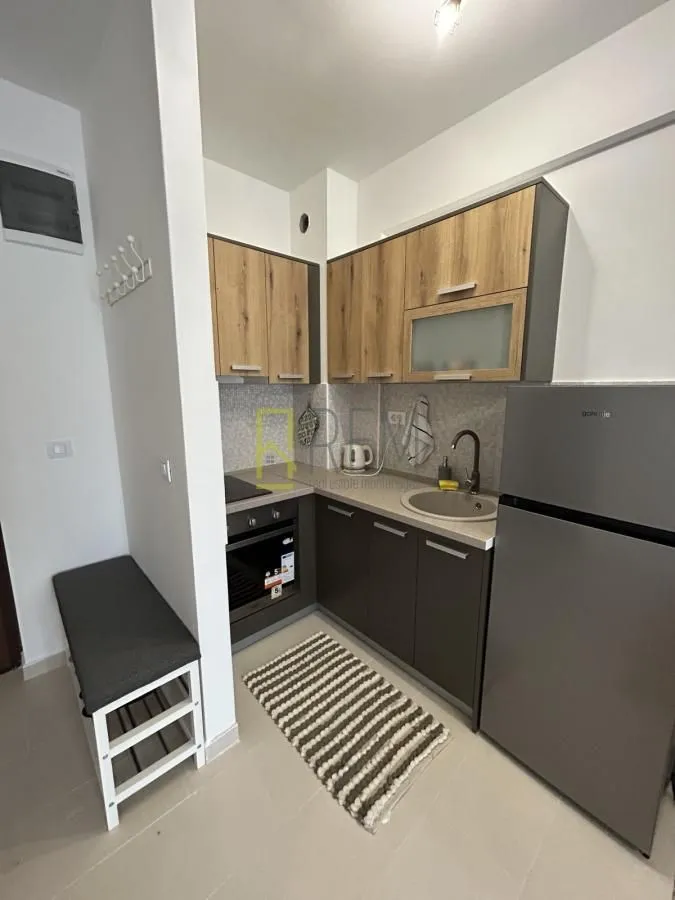 Small equipped kitchen with wooden cabinets and a refrigerator.