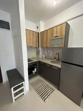 Small equipped kitchen with wooden cabinets and a refrigerator. - image 3