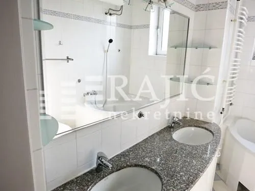 Bright bathroom with a double sink and a bathtub.